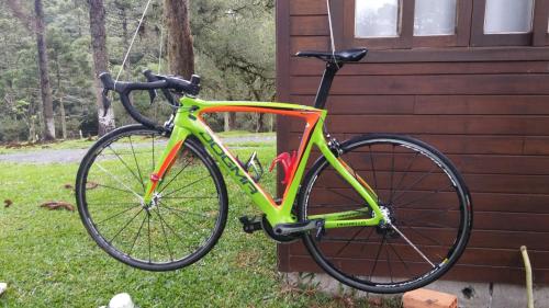 Una bicicleta encadenada a un lado de una casa en Pousada Cajuvá, en Urubici