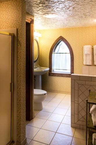 a bathroom with a toilet and a sink and a window at Landoll's Mohican Castle in Loudonville