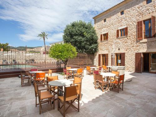 a patio with tables and chairs in front of a building at Ca' n Beia Suites - Adults Only in Alaró