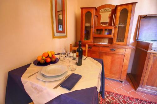 a table with a plate of fruit and a bottle of wine at App.to Le antiche Poste in Piegaro