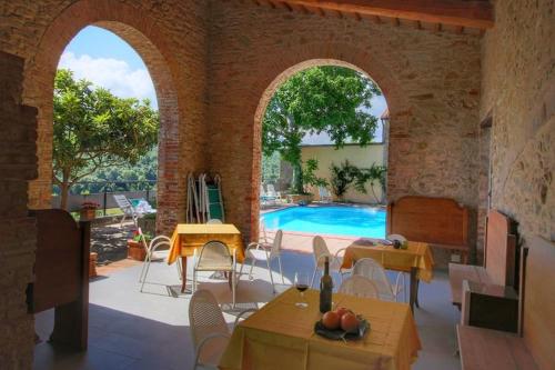 a patio with a pool and tables and chairs at App.to Le antiche Poste in Piegaro