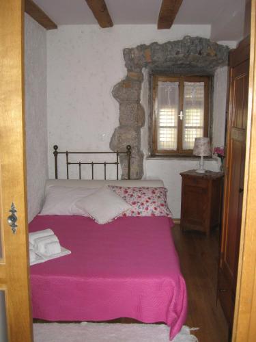 a bedroom with a bed with a pink blanket at Apartments Camellia & Magnolia in Volosko