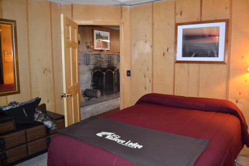 een slaapkamer met een bed en een open haard bij AJ's Lodge and Oven in Bergland