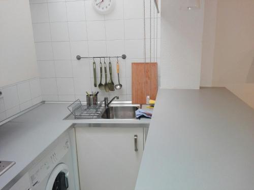 una cucina con lavandino e lavatrice di Céntrico Apartamento con Patio Privado a Siviglia