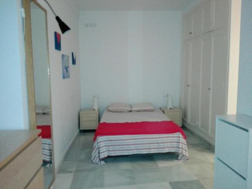 sypialnia z łóżkiem z czerwonym kocem w obiekcie Céntrico Apartamento con Patio Privado w Sewilli