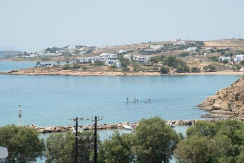 two people are in the water on a beach at Londos Hotel in Piso Livadi