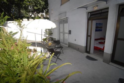 un patio con mesa, sillas y sombrilla en Apartment Maria en Split