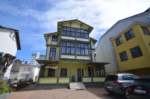 a yellow and white building with cars parked in front of it at Villa Baltic Dream in Międzyzdroje