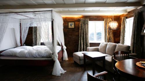 ein Schlafzimmer mit einem Himmelbett und einem Sofa in der Unterkunft Goldberghaus in Großschönau