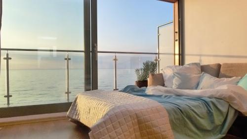 sypialnia z łóżkiem i widokiem na ocean w obiekcie Apartament na Klifie 14 w mieście Ustronie Morskie