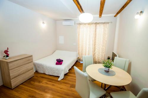 um pequeno quarto com uma cama e uma mesa em Sebenicum Apartments em Šibenik