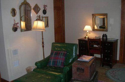 a living room with a green couch and a chair at Strawberry Farm B and B in Muscatine