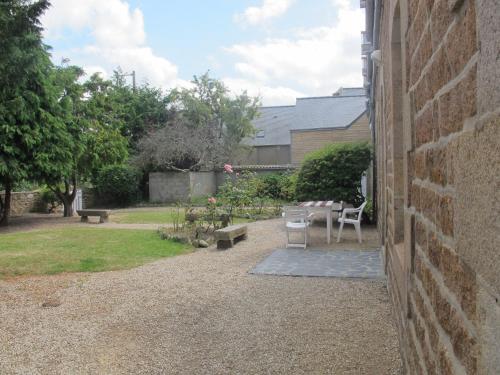 a patio with a table and chairs next to a building at Ecume de Mer in Trébeurden