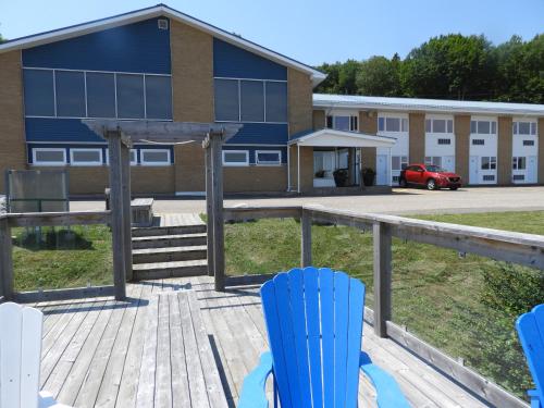 a deck with blue chairs in front of a building at Admiral Digby Inn Restaurant and Cottages in Digby