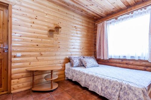 a bedroom with a bed and a table in a cabin at Vila Aura in Šventoji