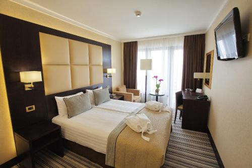 a hotel room with a bed and a television at Premier Hotel Dnister in Lviv
