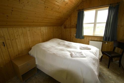 a bedroom with a bed in a wooden room at Artun Guesthouse in Artun