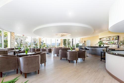 a restaurant with tables and chairs and windows at Hotel Terme Leonardo in Abano Terme