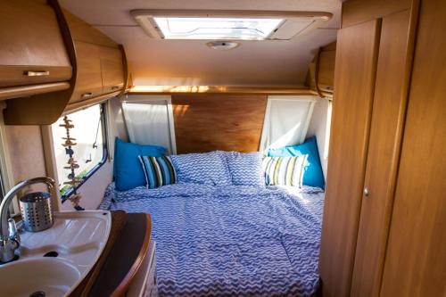 ein Schlafzimmer mit einem Bett und einem Waschbecken in einem Wohnwagen in der Unterkunft Caravan Apartment in Tinajo