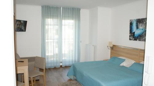 a bedroom with a bed and a desk and a chair at Apartament Magdalena in Świnoujście