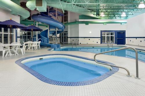a swimming pool with a slide in a building at Ramada by Wyndham Weyburn in Weyburn