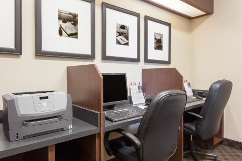 an office with a desk with a computer and a printer at Ramada by Wyndham Weyburn in Weyburn