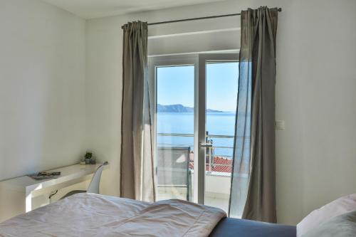 a bedroom with a bed and a view of the ocean at Apartments & Rooms Kata - Adults Only in Senj