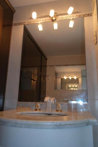 a bathroom with a sink and a large mirror at Torre Long Beach in Punta del Este