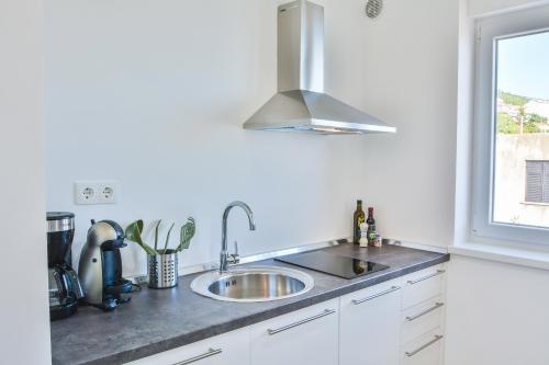 a kitchen counter with a sink and a window at Apartments & Rooms Kata - Adults Only in Senj