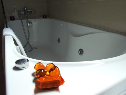 a bathroom with a bath tub with some orange rocks at Casa Do Vale Hotel in Évora