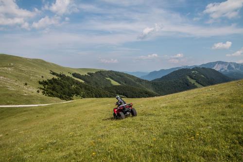 a person riding a motorcycle on a grassy hill at Hotel Han Bjelašnica in Bjelašnica