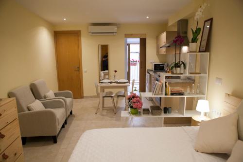 a living room with a bed and a table and chairs at El Faro Apartaments in Tarragona