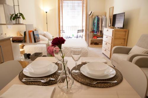 a living room with a table with plates and wine glasses at El Faro Apartaments in Tarragona