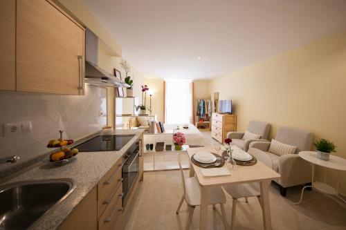 a kitchen and living room with a table and chairs at El Faro Apartaments in Tarragona