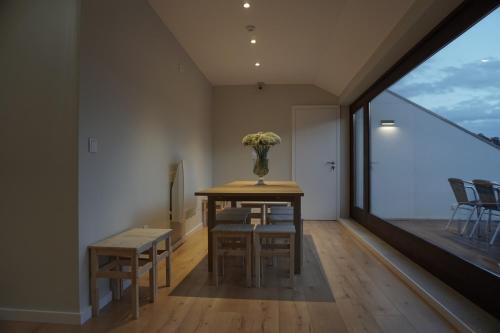 a dining room with a table and chairs and a large window at Feira Hostel & Suites in Santa Maria da Feira