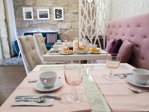 a table with two glasses and a table with food on it at 22 Oporto Guesthouse in Porto