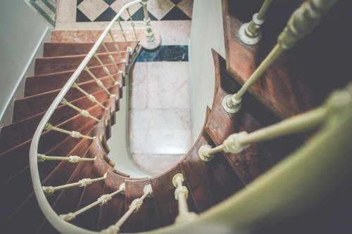 a wooden spiral staircase with a round window at OnJ S. Lazaro Lisboa in Lisbon