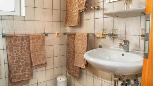 a bathroom with a sink and a mirror and towels at Ferien- und Monteurwohnung in Wohnbach in Wölfersheim