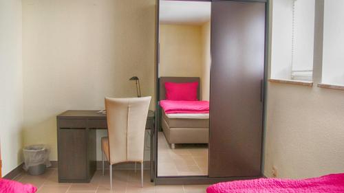 Zimmer mit einem Schreibtisch und einem Stuhl mit einem rosa Kissen in der Unterkunft Ferien- und Monteurwohnung in Wohnbach in Wölfersheim