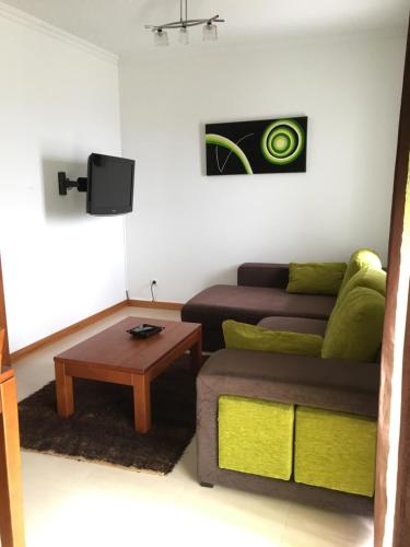 a living room with a couch and a coffee table at Nazaré T2 Vista Mar in Nazaré