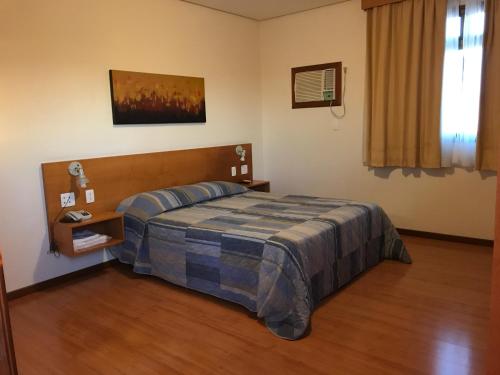 a bedroom with a bed in a room at Serema Palace Hotel in Lavras
