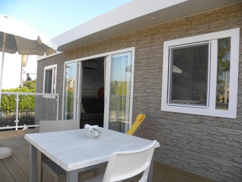 a white table and white chairs on a patio at ReBi Village in Imperia