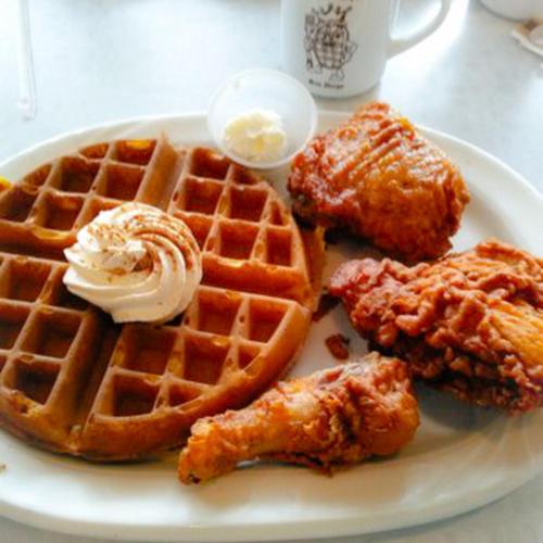 a plate offried chicken and waffles and chicken wings at Kings Inn in San Diego