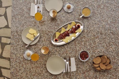 een tafel met borden eten en kopjes koffie bij Apartments Lucija-Klara in Brodarica