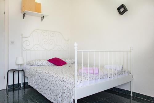 a bedroom with a white bed with pink pillows at Apartmani Krgu&scaron;ić in Tivat