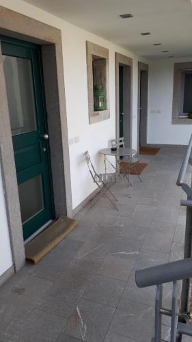 an empty hallway with a green door and a table at Casa Galante in Cividale del Friuli