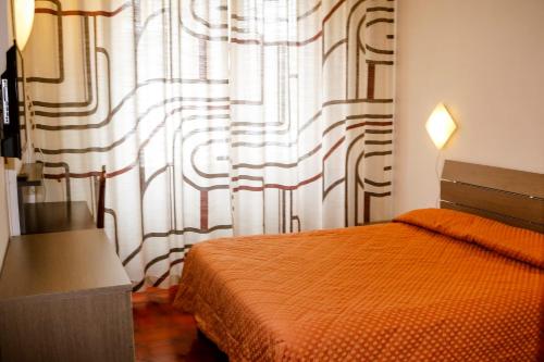 - une chambre avec un lit et une fenêtre avec un rideau dans l'établissement Hotel Giada, à Turin