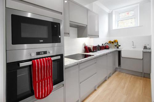 una cocina con una toalla roja colgada del horno en Ocean Outlook - Broadstairs Best!, en Broadstairs
