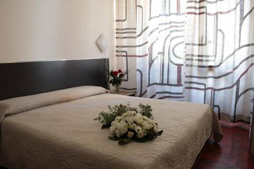 a bedroom with a bed with a flower arrangement on it at Hotel Giada in Turin