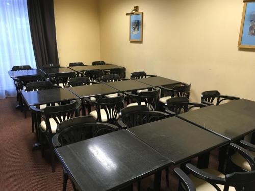 a row of tables and chairs in a room at Hotel Dorele in Montargis